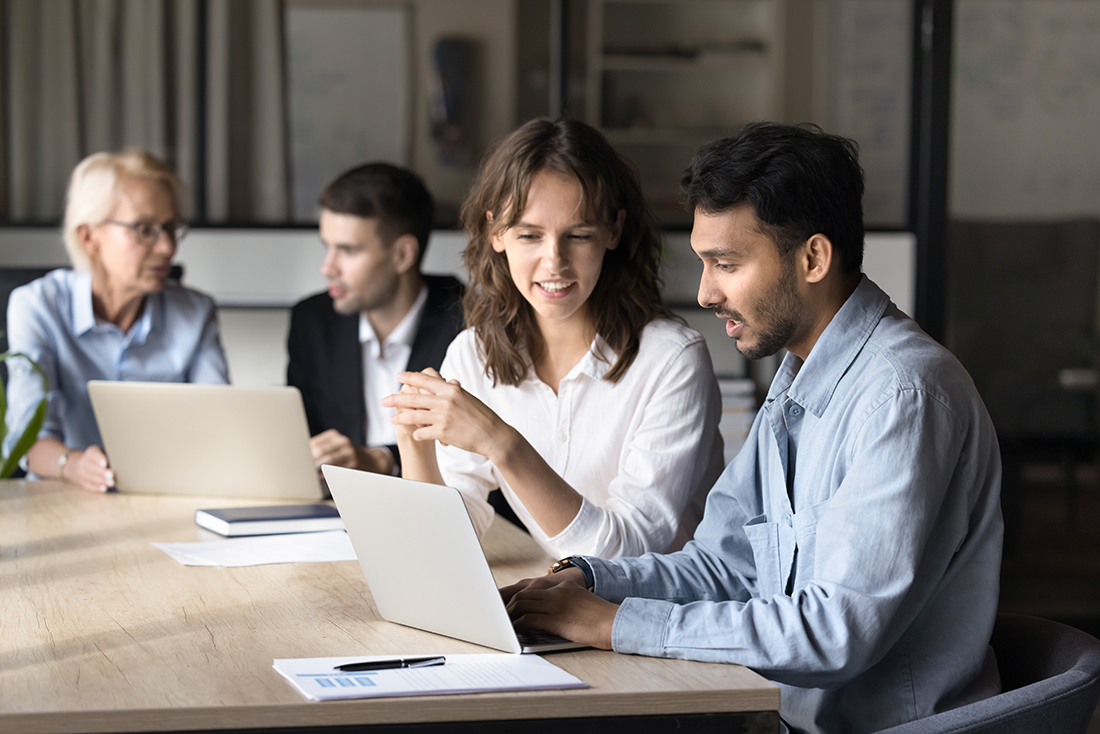 Two businesspeople discussing new project using laptop